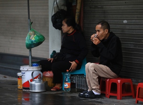 따뜻한 차 한 잔으로 몸을 녹이고 있는 하노이 시민